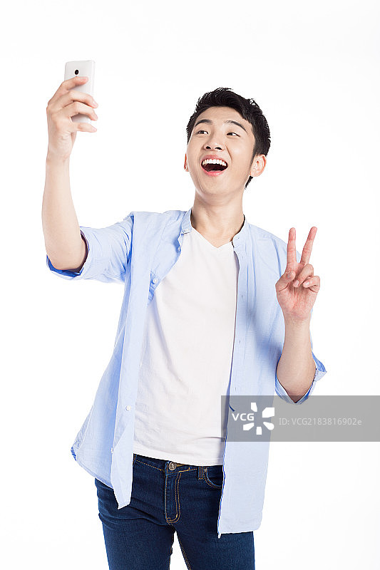 年轻男子使用手机自拍图片素材