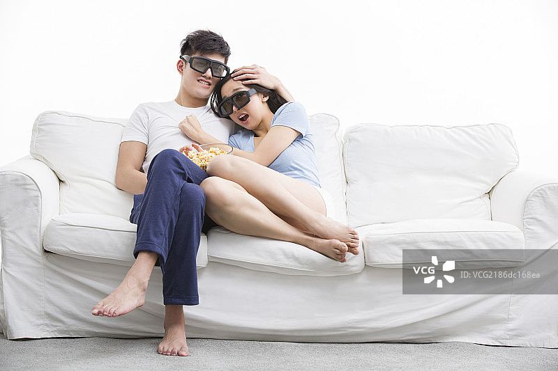 年轻情侣在客厅看3D电影图片素材