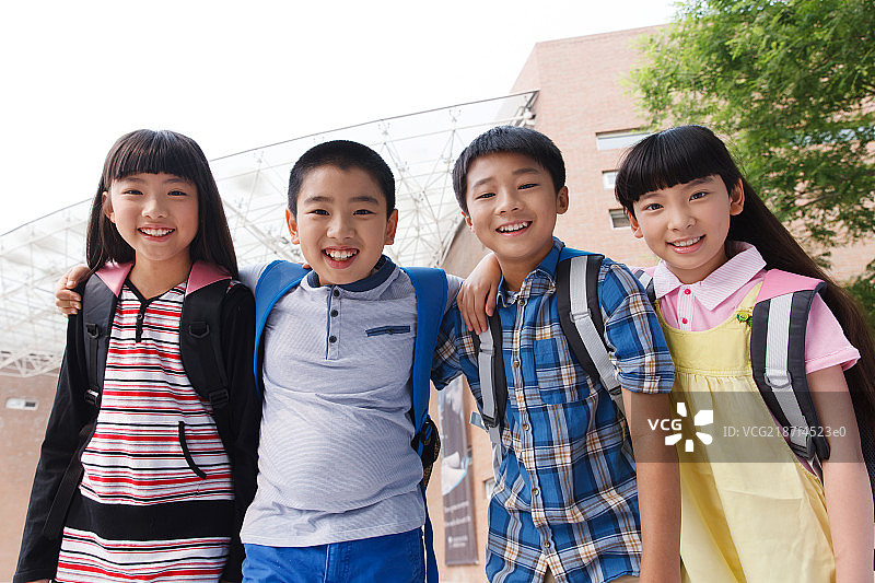 可爱的小学生在校园里搂着肩膀图片素材