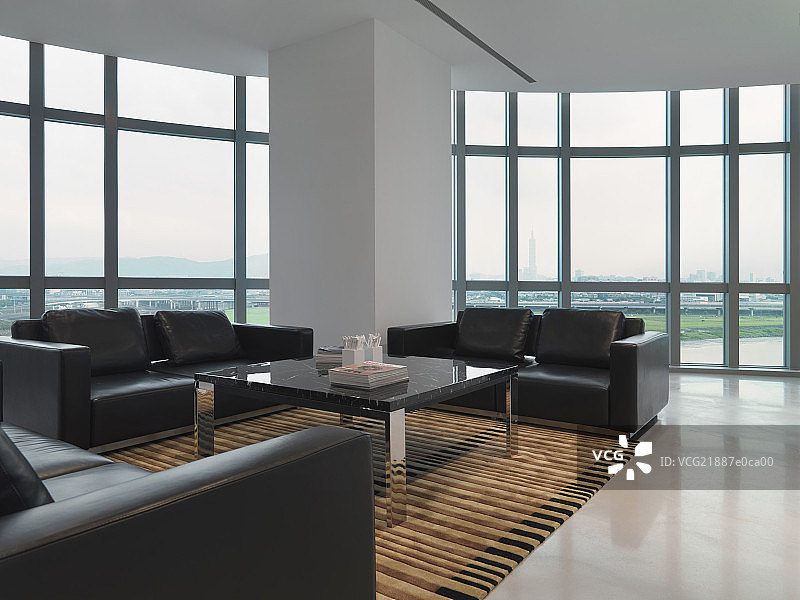 Black sofas in spacious lobby of modern office图片素材