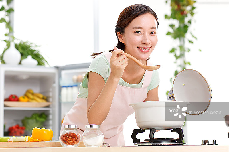 年轻女人在厨房做饭图片素材