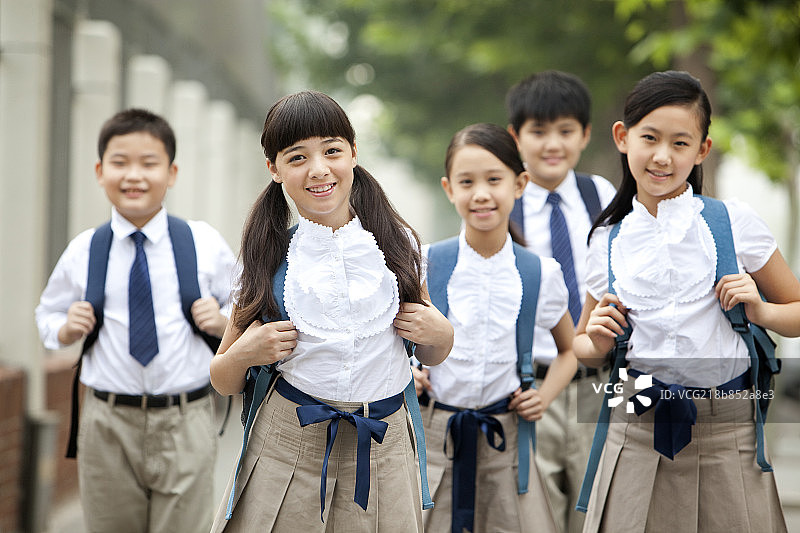 穿着校服的小学生在路上图片素材