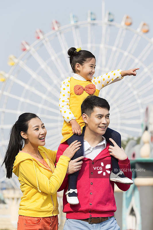 快乐的一家三口去游乐园玩图片素材