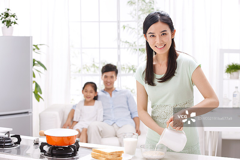 年轻女人在厨房做饭图片素材