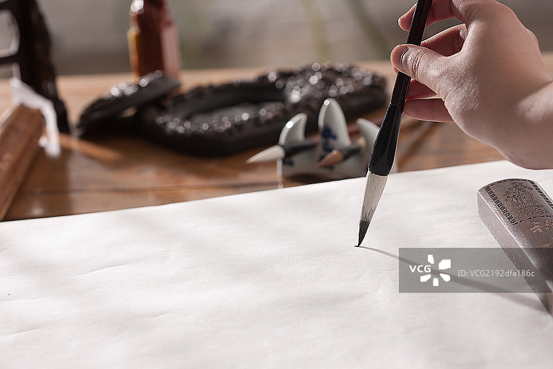 手拿毛笔写字图片素材