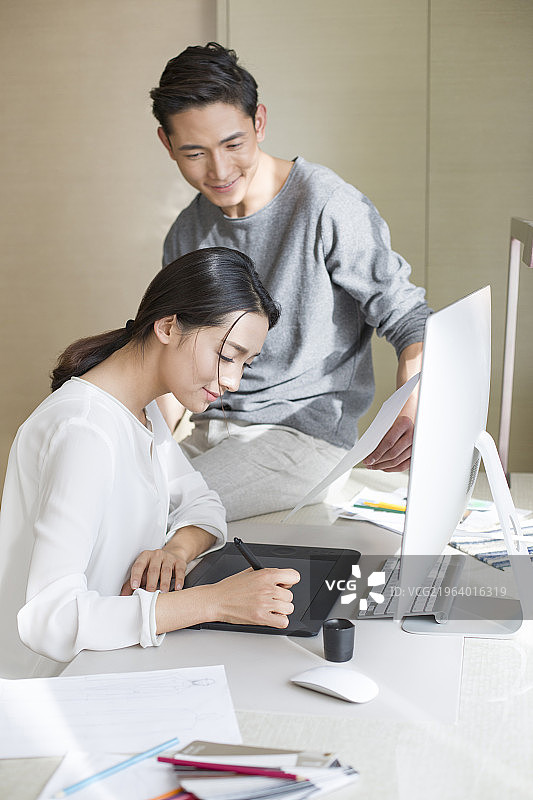 年轻服装设计师夫妇一起工作图片素材