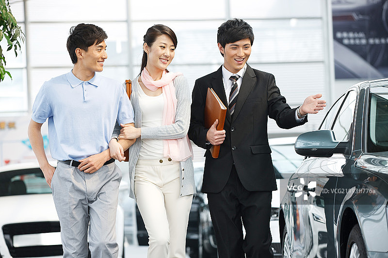青年夫妇在4S点购买汽车图片素材