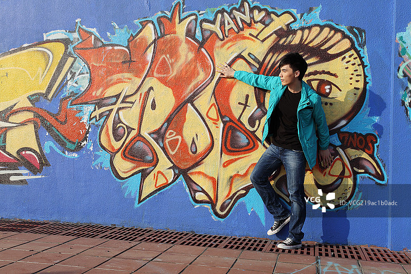 在艺术墙前的年轻人图片素材
