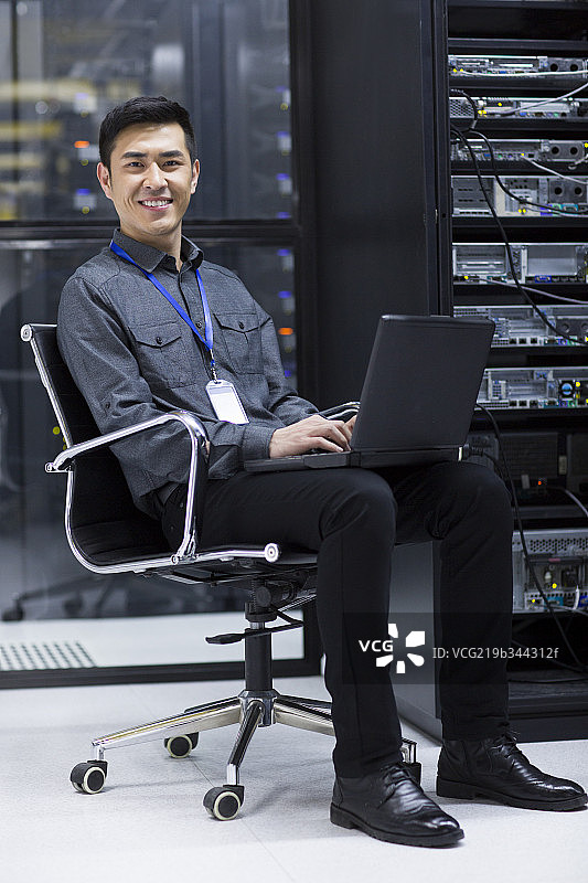 商务人士在机房使用笔记本电脑图片素材
