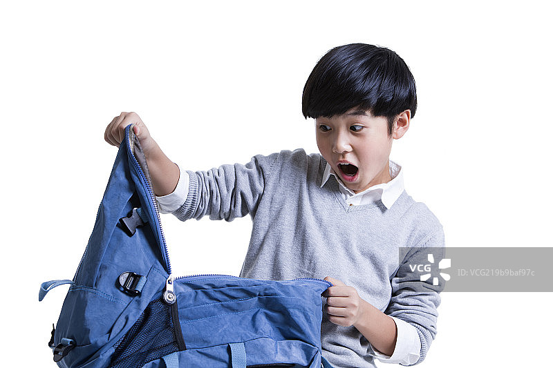惊讶的小男孩打开书包图片素材