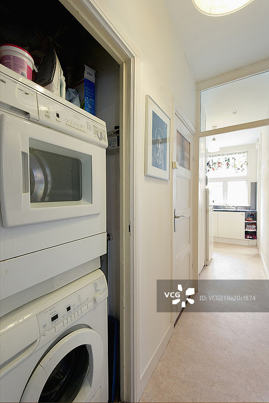 Washing machine along hallway with kitchen in the background图片素材