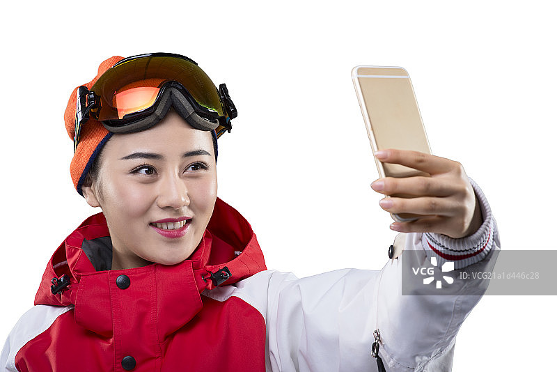 Young female skier making selfie on smartphone图片素材