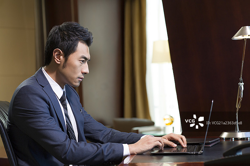 成功商务男士在书房使用笔记本电脑图片素材