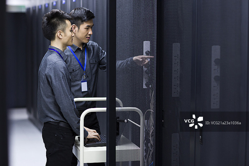 商务男士在机房使用笔记本电脑图片素材