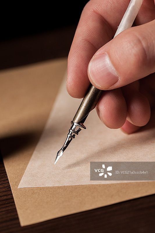 男人的手拿着鹅毛笔准备写字图片素材