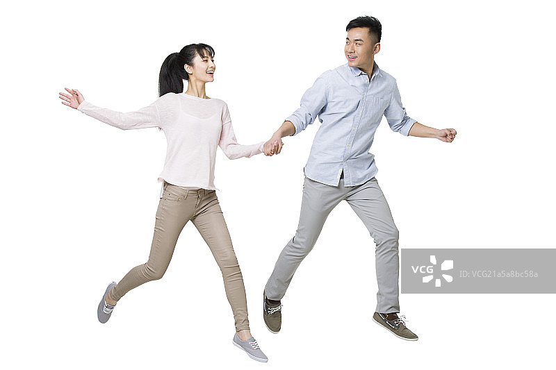 快乐的年轻情侣手牵手奔跑图片素材