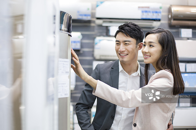 年轻情侣在家电商场挑选空调图片素材