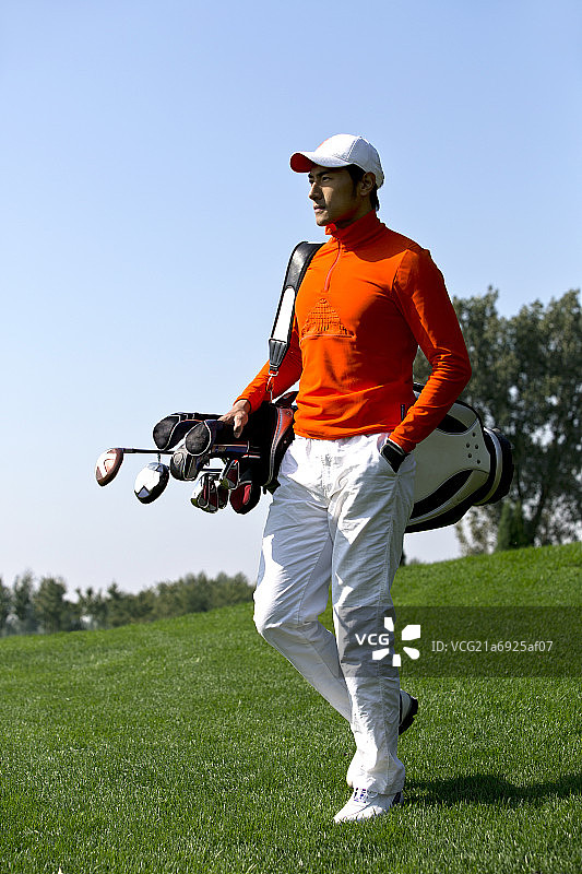 背着高尔夫球包的青年男人图片素材