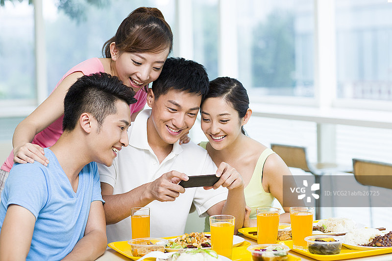 年轻人在餐厅给食物拍照图片素材