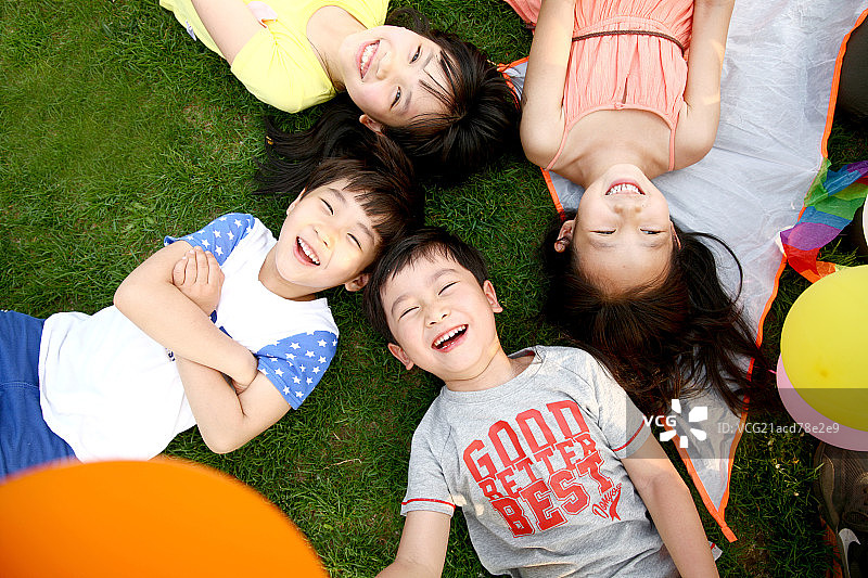 儿童躺在草地上玩耍图片素材