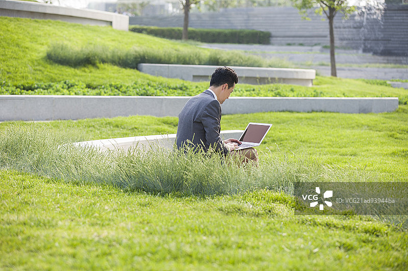 商务男士在户外使用笔记本电脑图片素材
