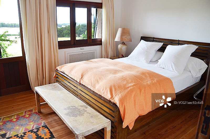 Bed and foot stool in bedroom图片素材