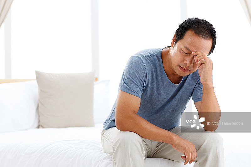 一个头痛的中年男人在卧室图片素材