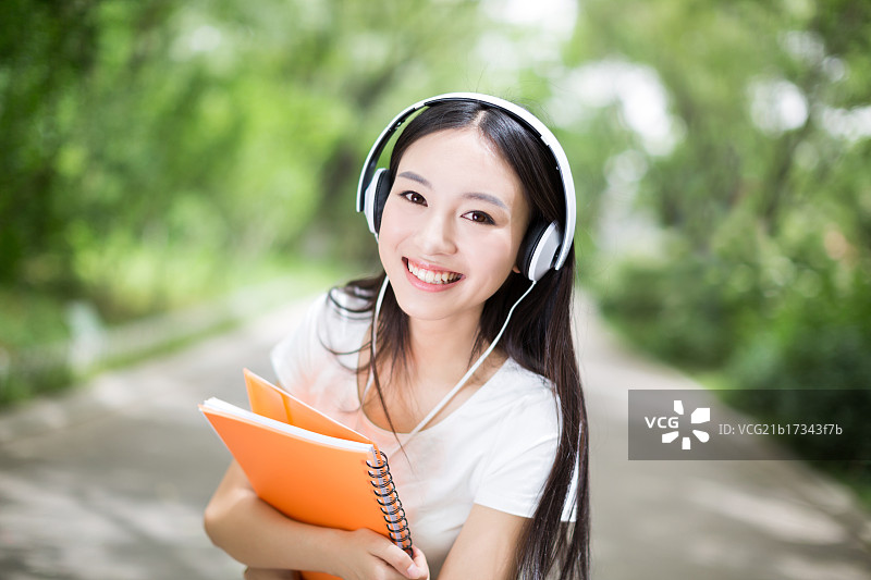 校园里听音乐的年轻女孩图片素材