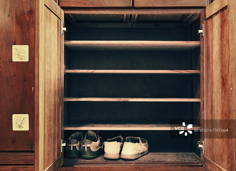 Two pairs of shoes in an old wooden cabinet图片素材