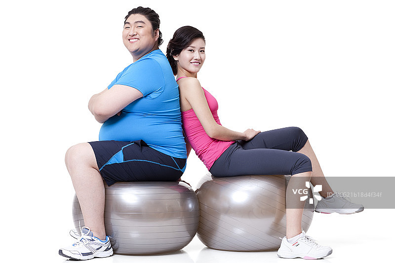 胖子和女友坐在健身球上图片素材
