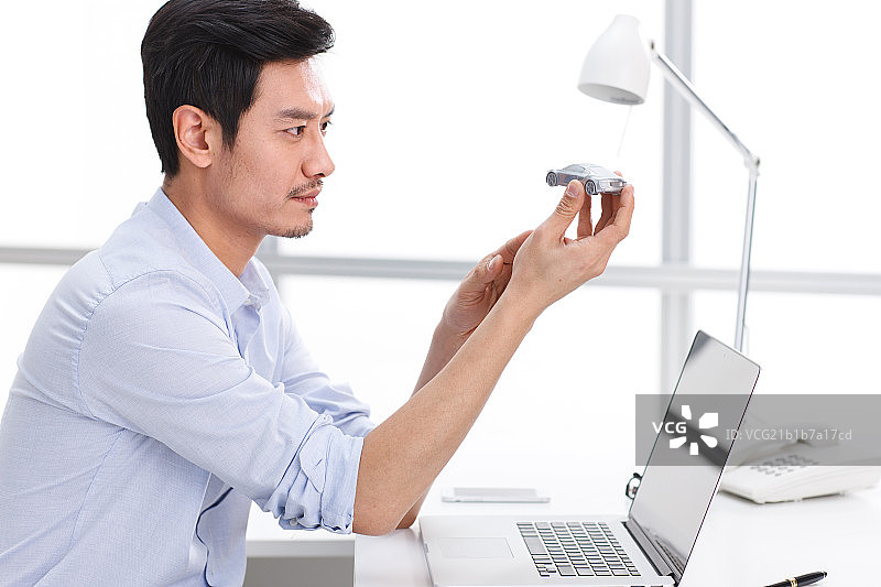 男白领拿着汽车模型图片素材