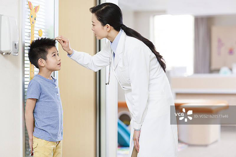 医生给小男孩量身高图片素材