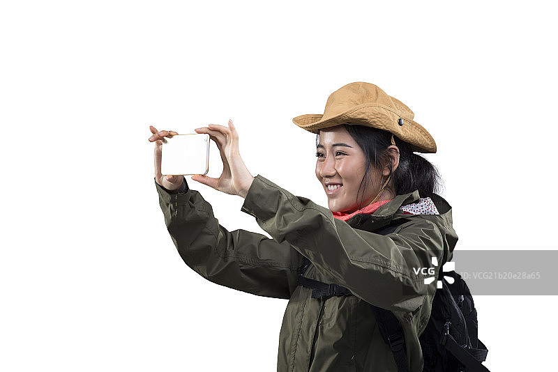 Young female mountain climber taking cell phone picture图片素材