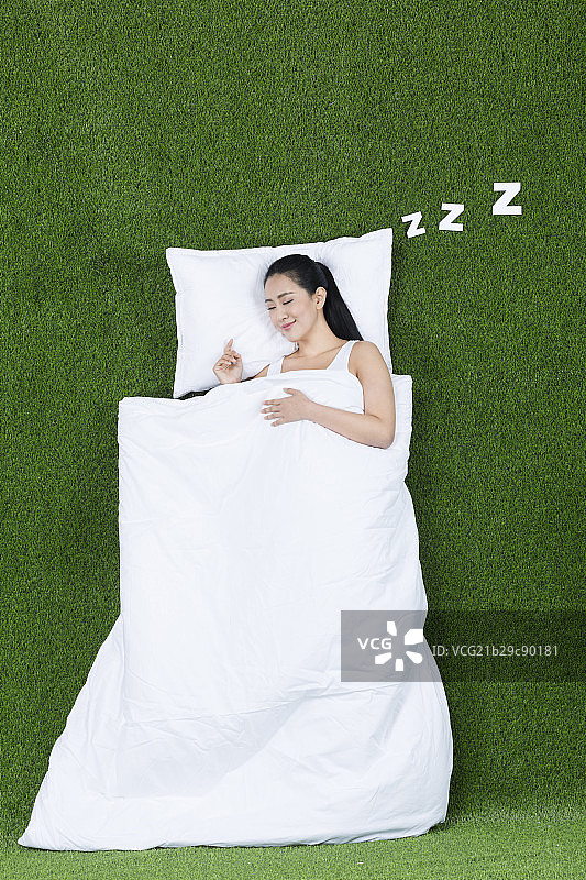 草地创意睡觉的年轻女子图片素材