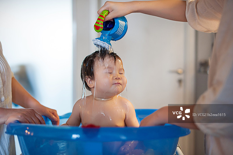 Baby boy being bathed by mother图片素材
