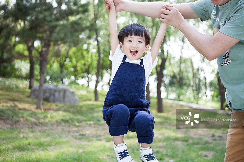 拉着爸爸在草地玩耍图片素材