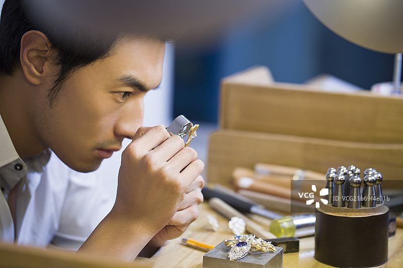 珠宝设计师用微型放大镜检查钻石图片素材