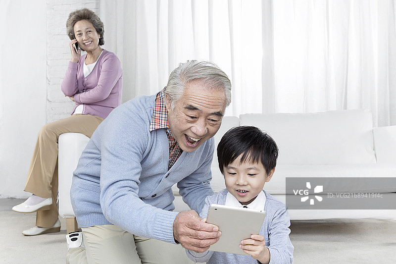 穿休闲服装坐在沙发上的祖孙三人图片素材