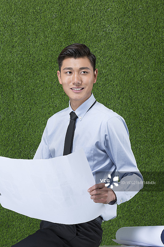 草地商务男设计师看图纸图片素材