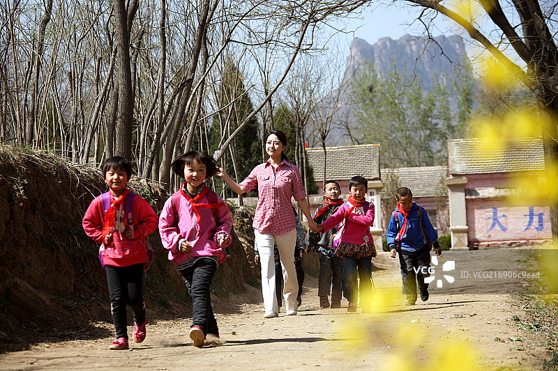 乡村小学生和老师走在路上图片素材