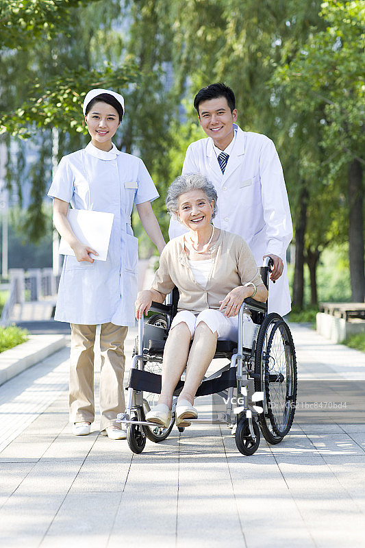 医生护士与坐着轮椅的老人图片素材