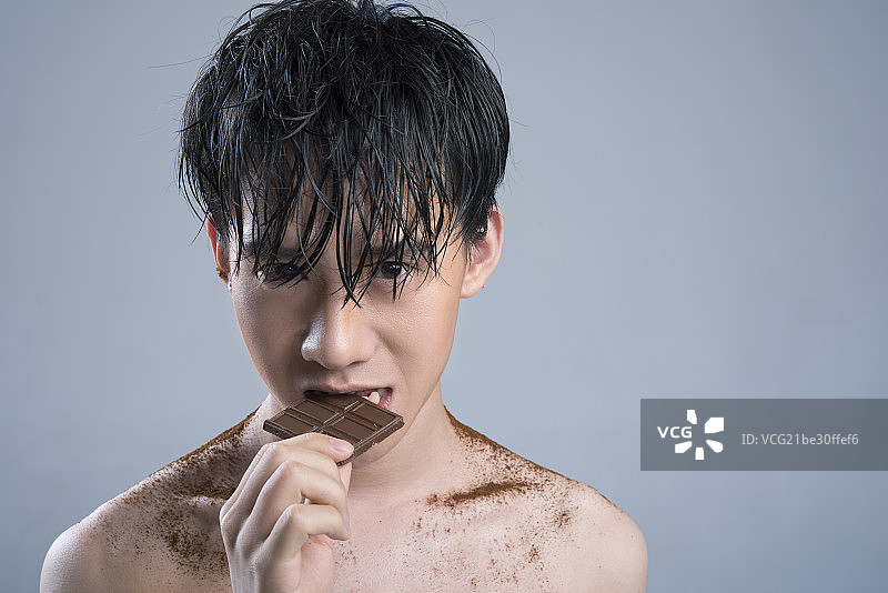 Young man eating chocolate图片素材