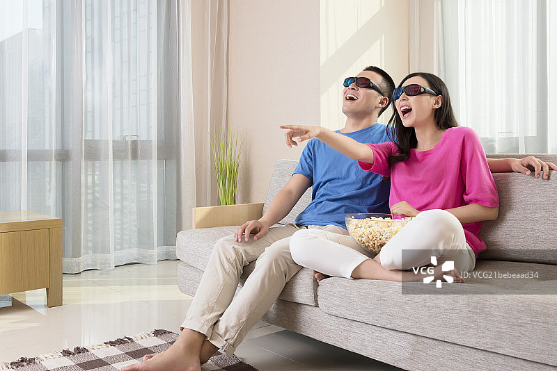 Young couple watching 3D TV图片素材