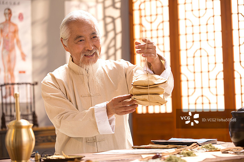 老中医拿着中药包图片素材