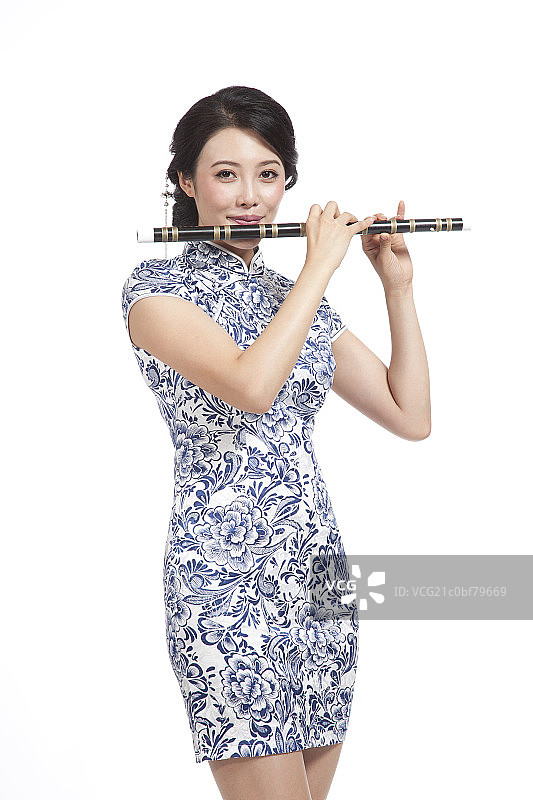 棚拍身穿中国传统服装的年轻女人吹箫图片素材