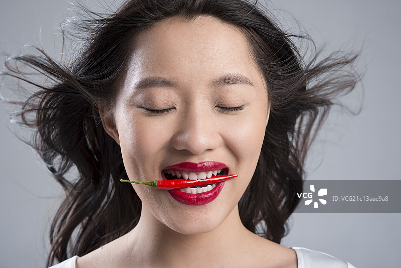 Young woman eating pepper图片素材