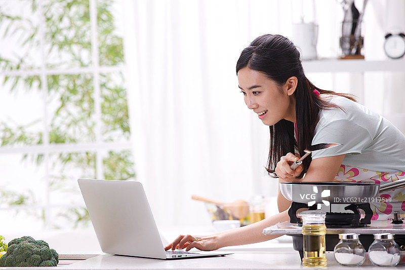 一个年轻女人在厨房做饭图片素材