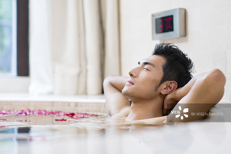 年轻男子泡花瓣浴图片素材