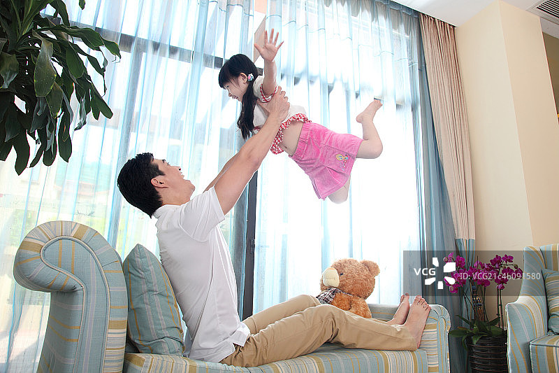 坐在客厅沙发上的父女图片素材