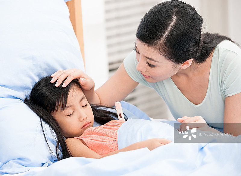 母亲正在为女儿测量体温图片素材